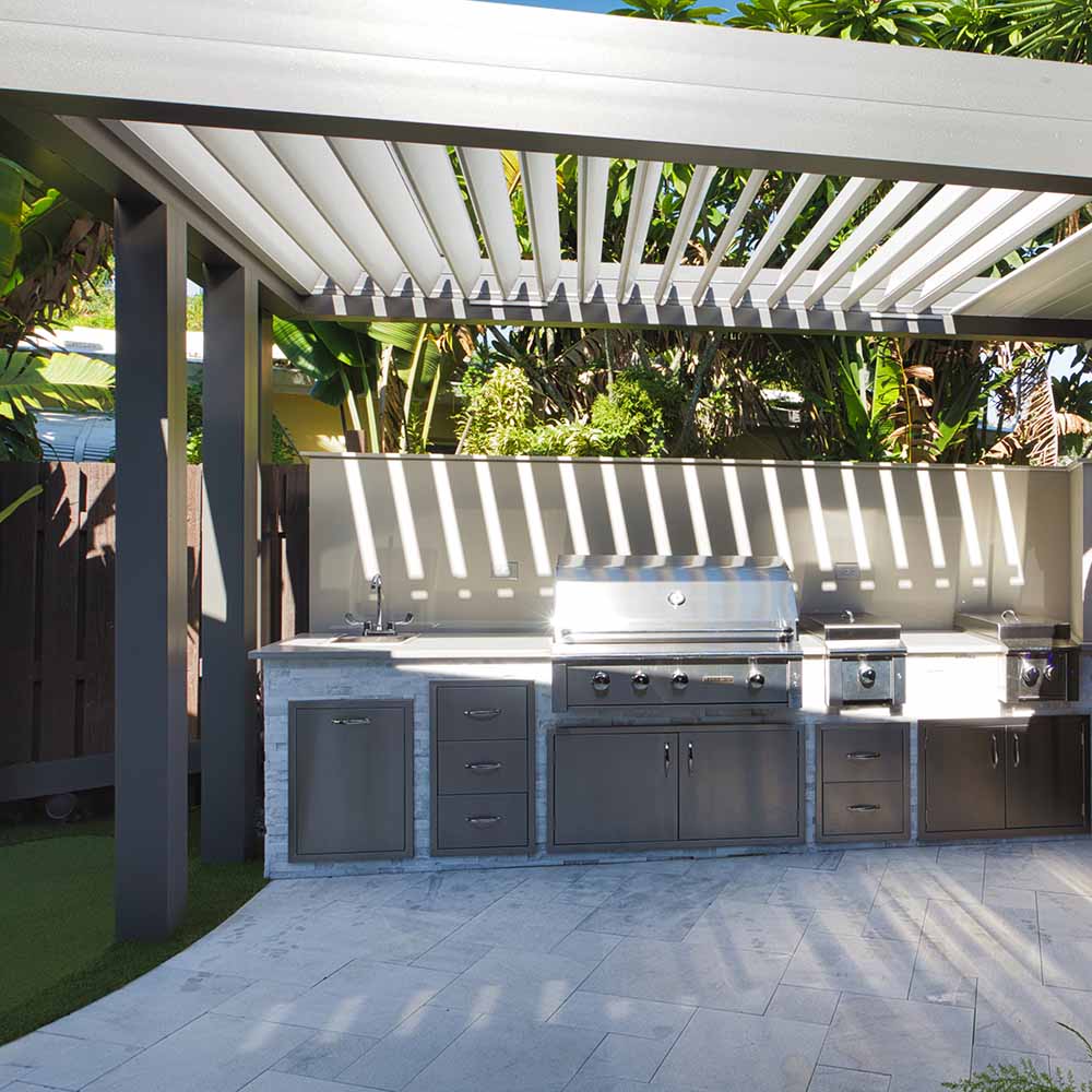 Louvered pergola with integrated outdoor kitchen and grill | Seattle's Premier Pergola and Outdoor Kitchen Installer | The pergola features an adjustable roof for sun control, perfect for outdoor dining year-round.